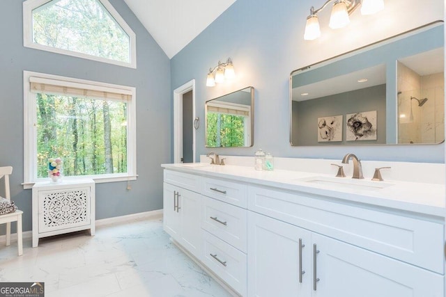 bathroom featuring lofted ceiling, a healthy amount of sunlight, and vanity