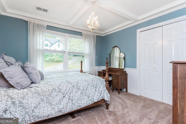 carpeted bedroom with beam ceiling, a closet, and crown molding