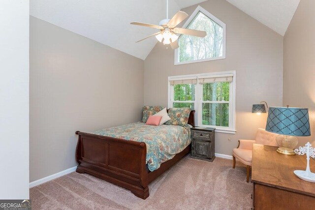 carpeted bedroom featuring ceiling fan, multiple windows, and high vaulted ceiling