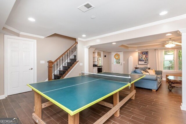 rec room with ornamental molding, dark wood-type flooring, ceiling fan, and decorative columns