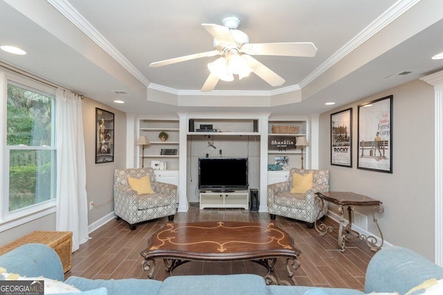 living room featuring ornamental molding, dark wood-type flooring, ceiling fan, and a raised ceiling