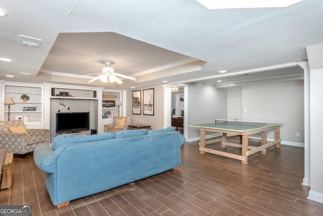 living room with ornamental molding, dark hardwood / wood-style flooring, ceiling fan, and a raised ceiling