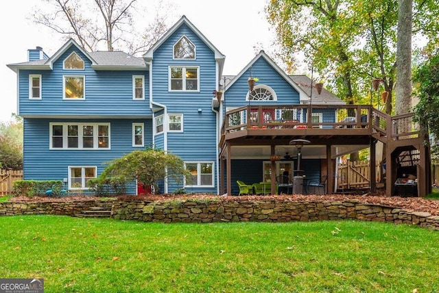 rear view of house with a wooden deck and a yard