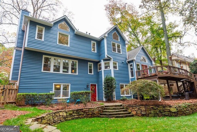 back of house with a yard and a deck