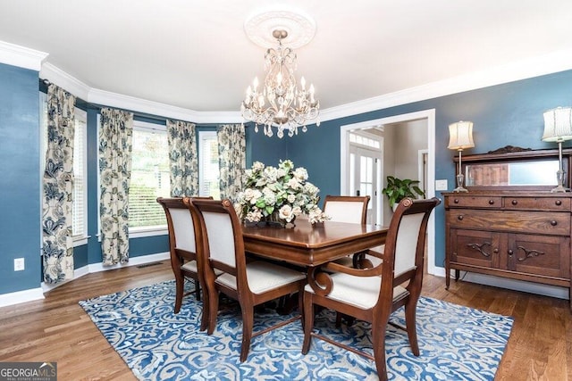 dining area featuring ornamental molding, plenty of natural light, and hardwood / wood-style flooring