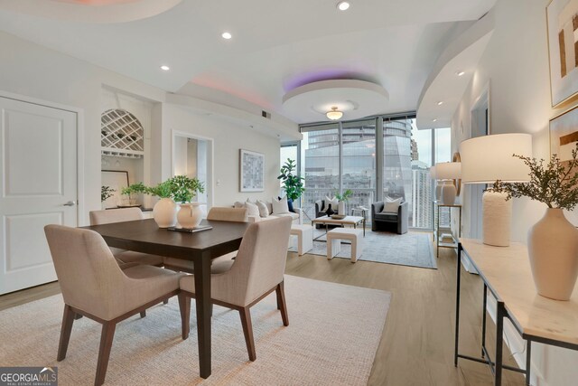 dining room featuring expansive windows and light hardwood / wood-style flooring