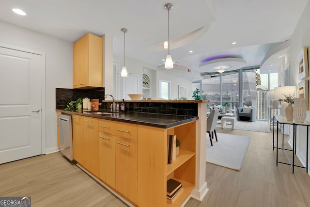 kitchen with tasteful backsplash, light brown cabinets, kitchen peninsula, and sink