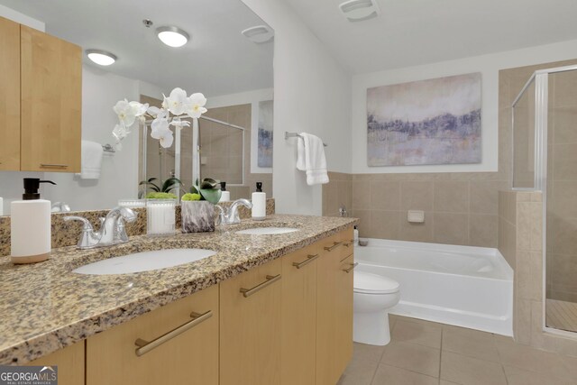 full bathroom with tile walls, vanity, plus walk in shower, tile patterned flooring, and toilet