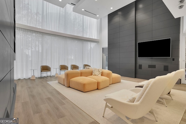 living room with light hardwood / wood-style floors and a high ceiling