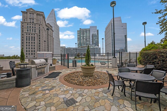 view of patio featuring area for grilling, a community pool, and exterior kitchen