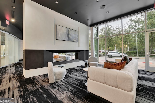 living room with expansive windows, hardwood / wood-style flooring, and a towering ceiling