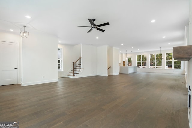 unfurnished living room featuring dark hardwood / wood-style flooring and ceiling fan