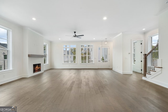 unfurnished living room with dark hardwood / wood-style flooring, ceiling fan, and crown molding