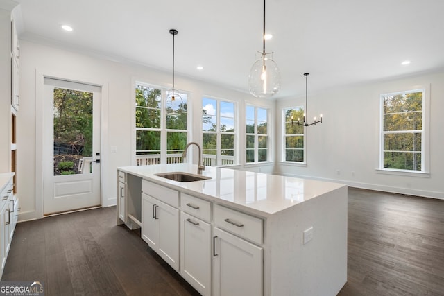 kitchen featuring pendant lighting, a wealth of natural light, sink, and white cabinets