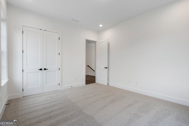 unfurnished bedroom with a closet and carpet floors