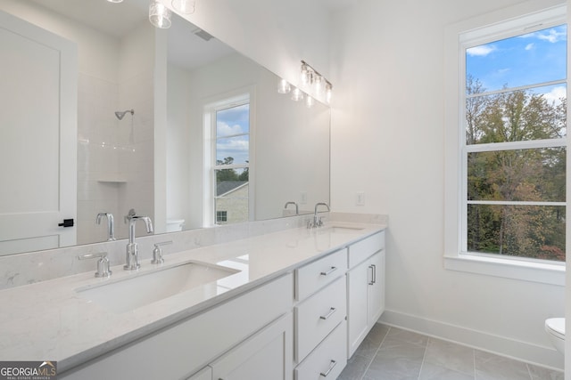 bathroom featuring vanity, a healthy amount of sunlight, and toilet