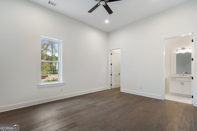 unfurnished bedroom featuring dark wood-type flooring, ceiling fan, and connected bathroom