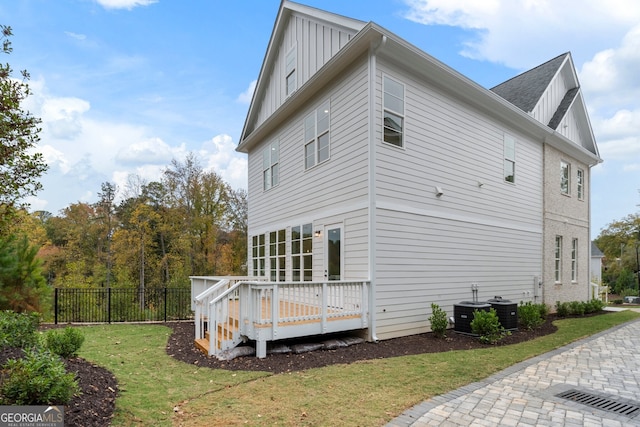 view of side of home with a wooden deck and a yard