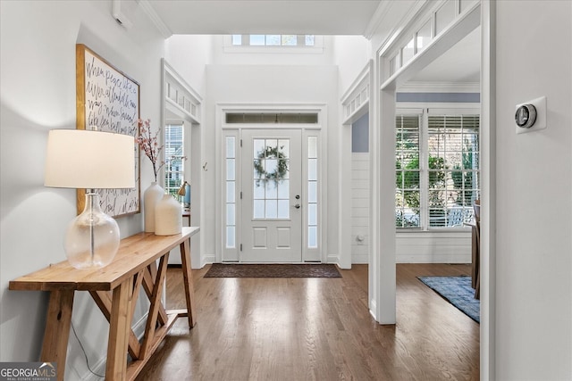 entrance foyer with crown molding and dark hardwood / wood-style floors