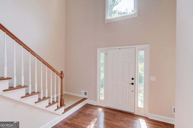 foyer featuring hardwood / wood-style floors and a towering ceiling