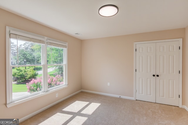 empty room with a wealth of natural light and light carpet