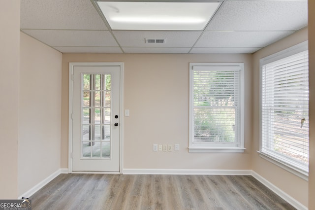 doorway featuring hardwood / wood-style floors, a wealth of natural light, and a paneled ceiling