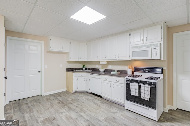 kitchen with sink, a drop ceiling, white appliances, light hardwood / wood-style flooring, and white cabinets