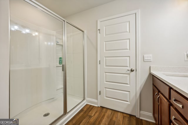 bathroom featuring walk in shower, wood-type flooring, and vanity