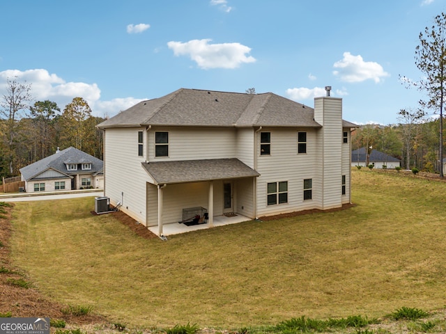 rear view of property with central air condition unit, a yard, and a patio area