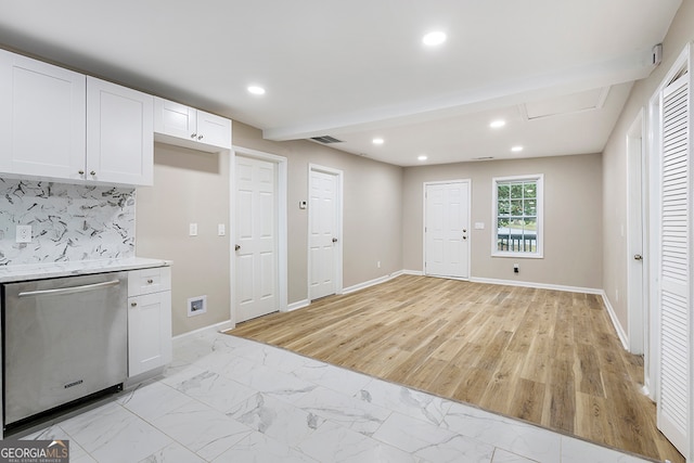 kitchen featuring dishwasher, beam ceiling, backsplash, white cabinetry, and light wood-type flooring