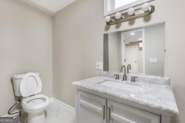 half bathroom with toilet, marble finish floor, baseboards, and vanity