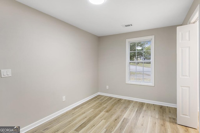 unfurnished room with visible vents, light wood-style flooring, and baseboards