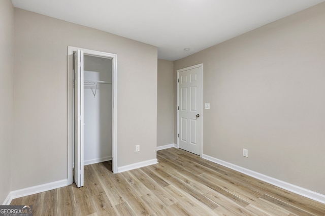 unfurnished bedroom with a closet and light wood-type flooring