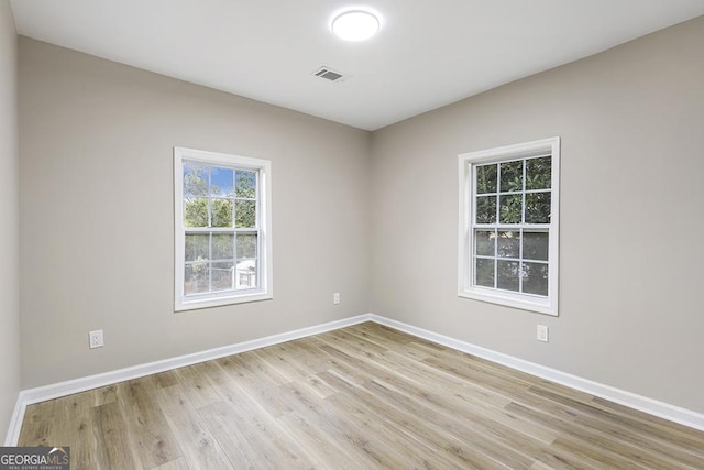 unfurnished room featuring baseboards and light wood-style floors