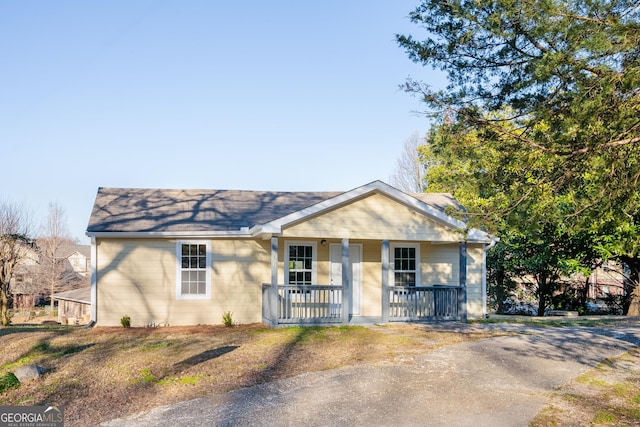 view of front of property featuring a porch and roof with shingles