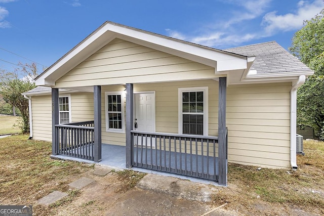 bungalow-style home with a porch and roof with shingles