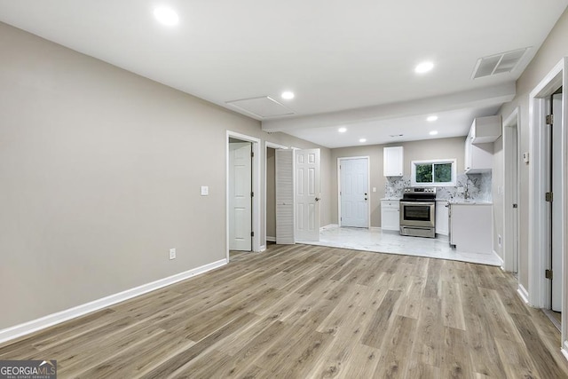 unfurnished living room with light wood-style flooring, baseboards, and recessed lighting