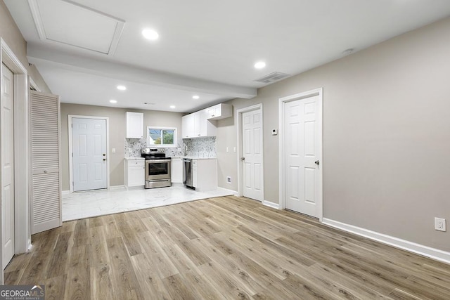 kitchen featuring tasteful backsplash, white cabinets, light wood-style flooring, stainless steel appliances, and light countertops