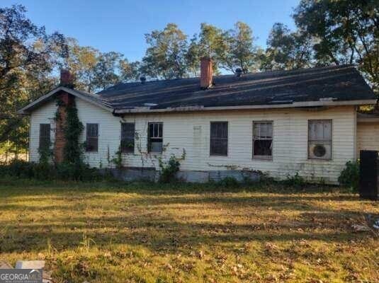 rear view of house featuring a yard