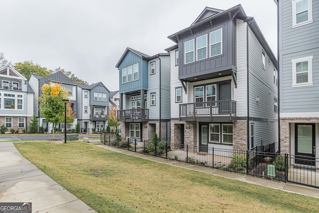 view of property with a front lawn and a balcony