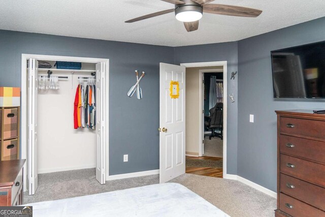 bedroom featuring ceiling fan, light colored carpet, and a textured ceiling