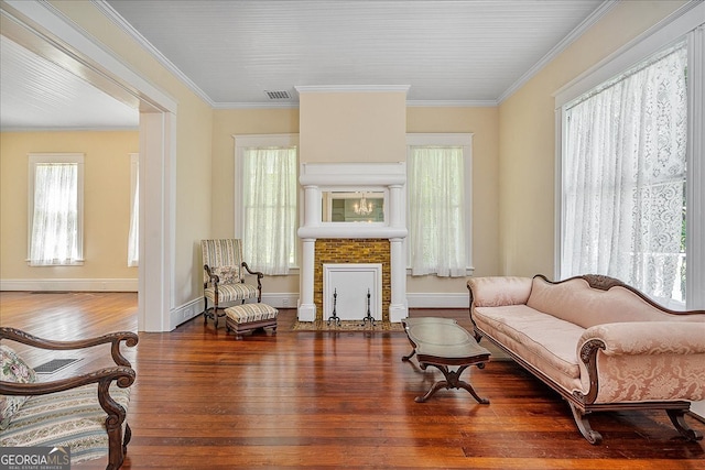 living area with wood-type flooring and crown molding