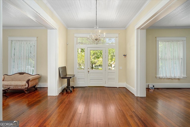 foyer featuring hardwood / wood-style floors, a notable chandelier, and crown molding