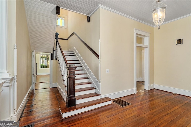 stairs with hardwood / wood-style flooring and crown molding