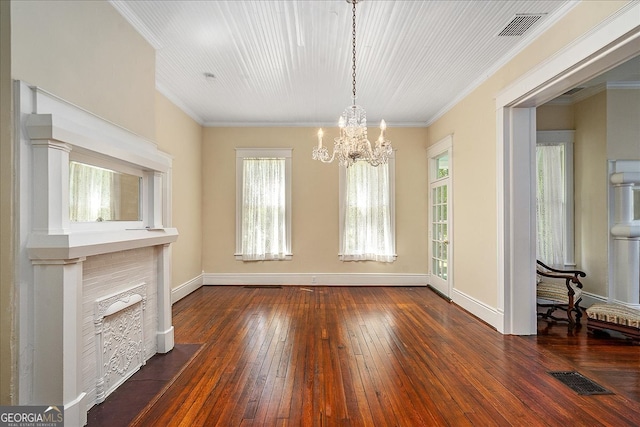 unfurnished dining area featuring dark hardwood / wood-style floors, crown molding, and an inviting chandelier