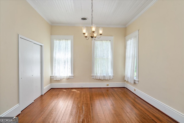 unfurnished dining area with ornamental molding, wood-type flooring, and a notable chandelier