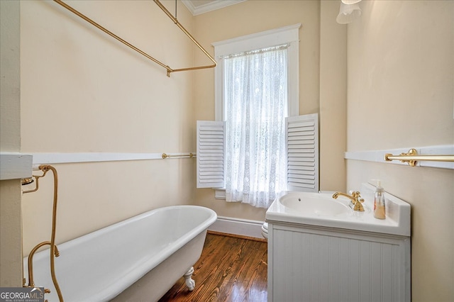 bathroom featuring wood-type flooring, a tub, crown molding, and plenty of natural light