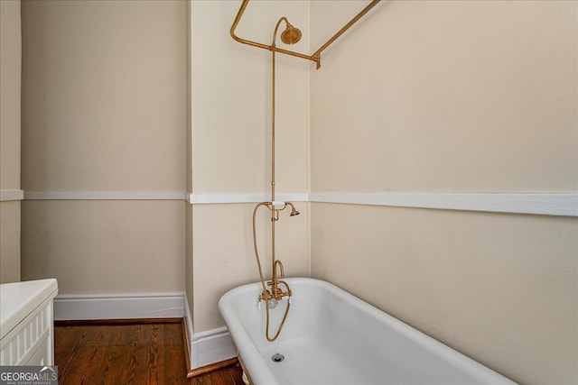 bathroom with wood-type flooring and a tub to relax in