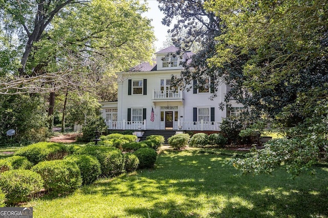 view of front facade featuring a front lawn and a balcony