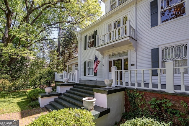 view of exterior entry featuring a balcony